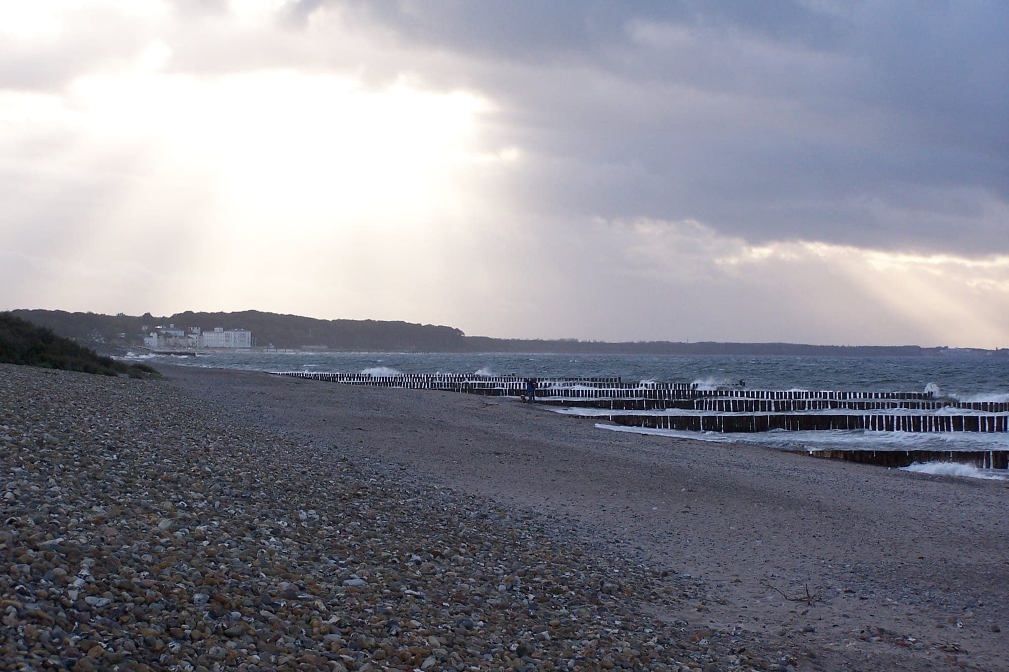 Strand bei Börgerende mit Buhnen und Blick auf Heiligendamm im Licht der Wolken