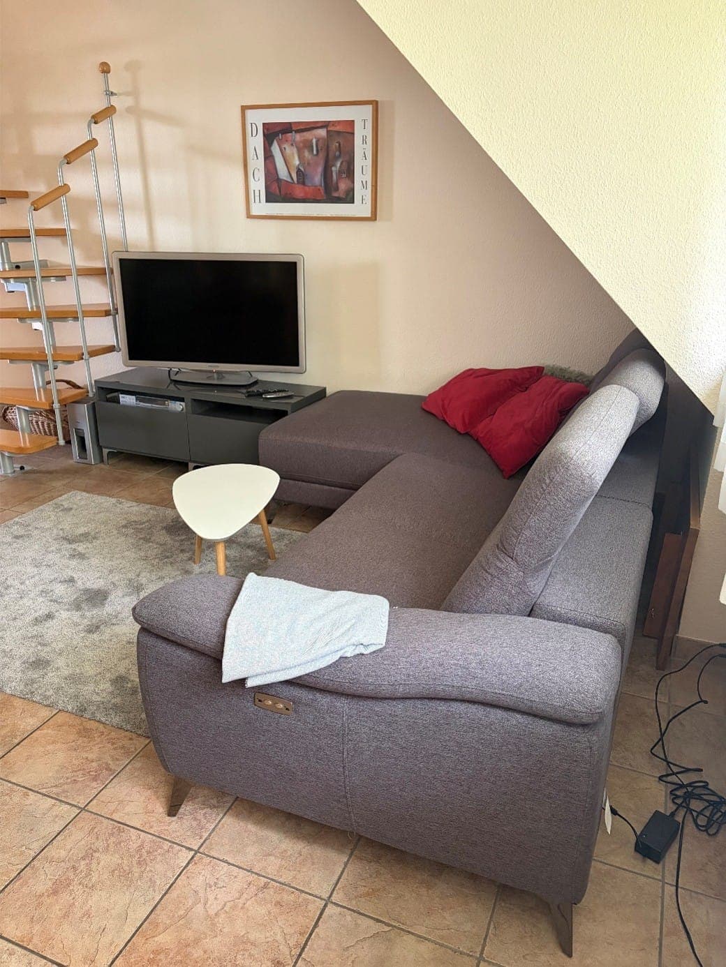 Wohnzimmer der Wohnung II mit Sofa und Treppe ins Dachgeschoss